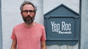 Nathan Golub alongside Yep Roc Records sign