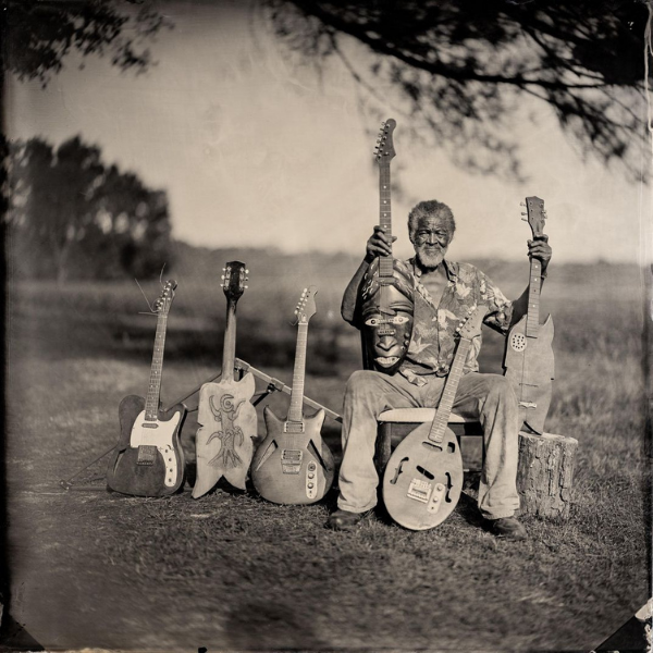 Tin type photograph of Freeman Vines holding his carved guitars