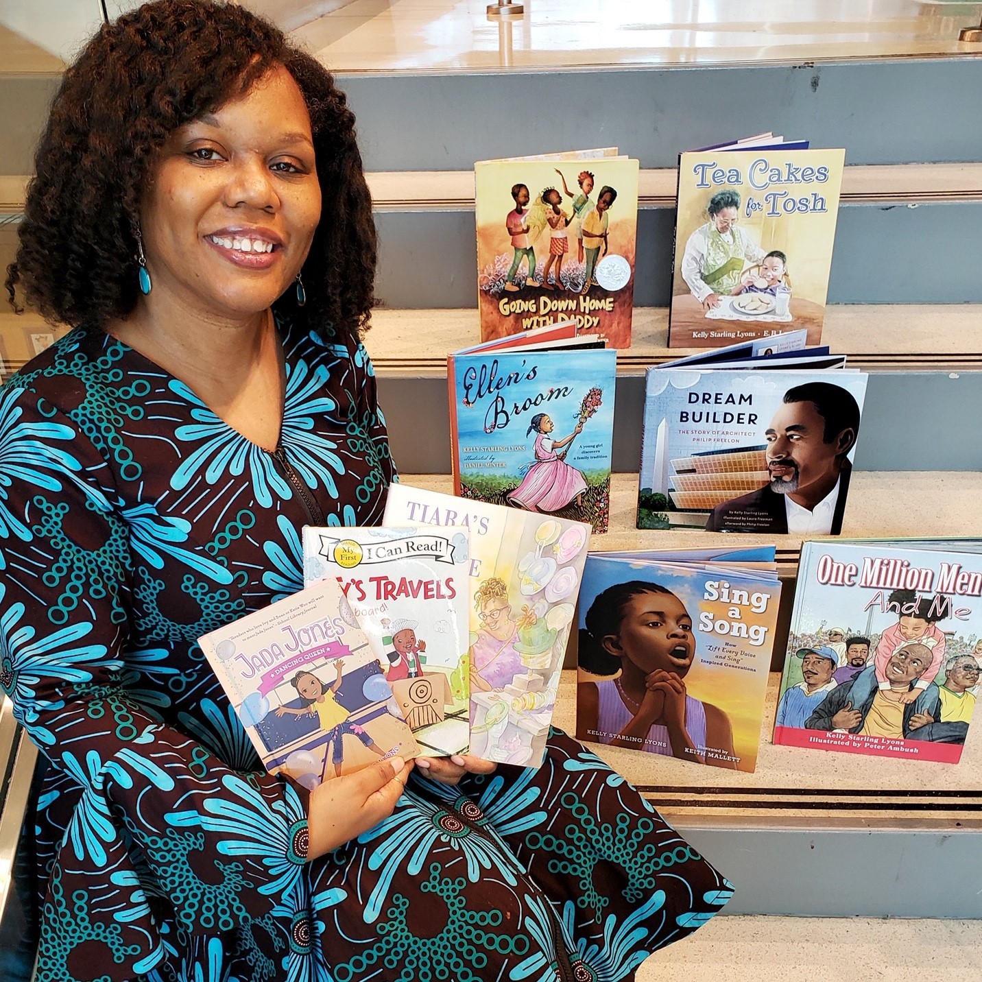 Kelly Starling Lyons holds several of her children's book titles