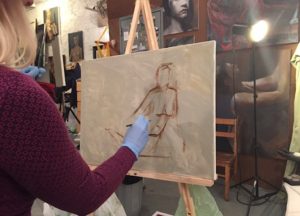 pastel sketch of a female figure being created by a gloved hand