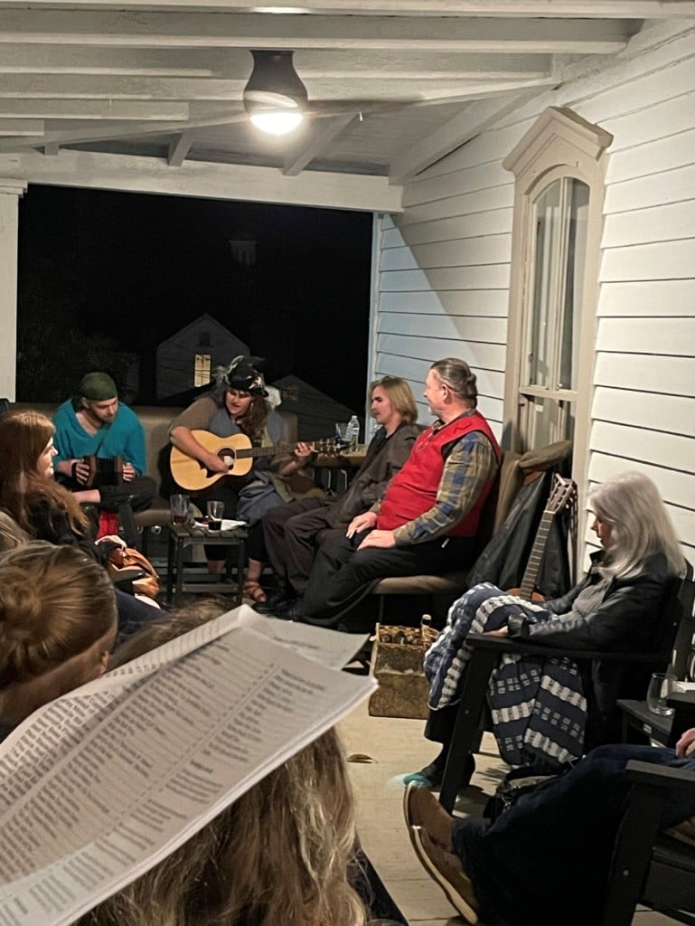 people circled with guitars singing together