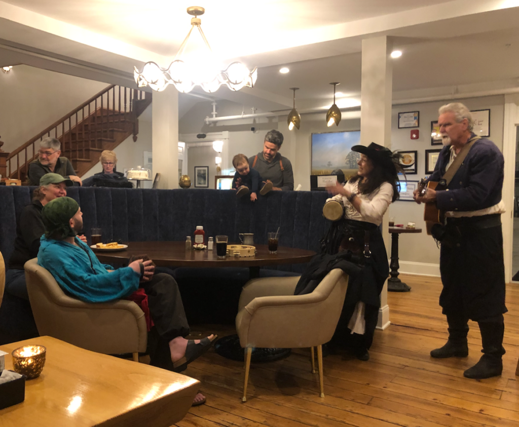 group of people singing in the lobby of the Colonial Inn