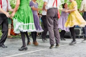 Legs of cloggers in brightly colored period clothing showing movement on stage