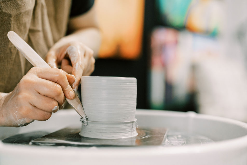 someone shaping a pottery piece on a wheel